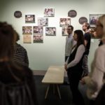 Foto des medienpädagogischen Küchentalks #8. In einem Raum des Museums für Kommunikation steht eine Gruppe Menschen, die in dieselbe Richtung blicken.