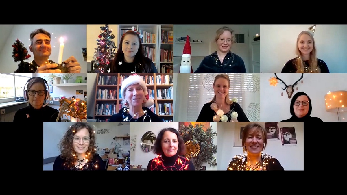 Screenshot des GMK-Weihnachtsgruß. Die einzelnen Mitglieder des Geschäftsstellenteams sind mit Lichterketten, Kerzen oder weihnachtlichen Dekoration geschmückt.