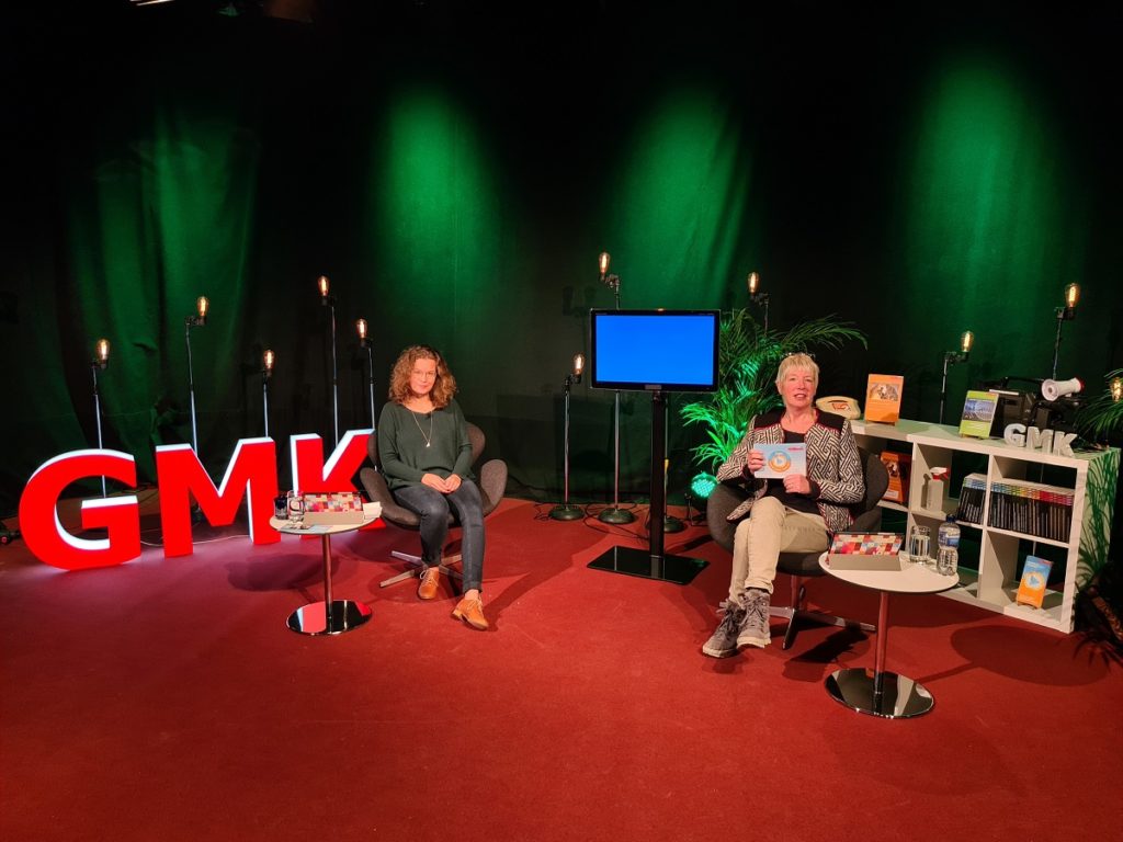 Foto des Studios des Forums Kommunikationskultur 2020. Im Studio sitzen Anja Pielsticker und Andrea Marten. Zwischen ihnen ist ein Fernsehbildschirm aufgebaut.