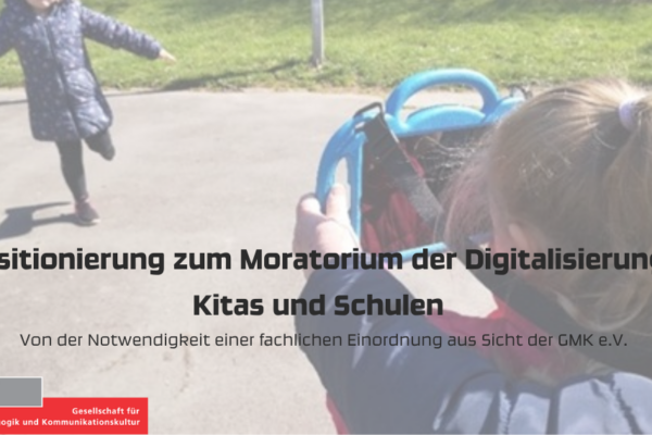 Kleines Mädchen fotografiert anderes kleines Mädchen mit Tablet; Text: Positionierung zum Moratorium der Digitalisierung in Kitas und Schulen. Von der Notwendigkeit einer fachlichen Einordnung aus Sicht der GMK e.V.