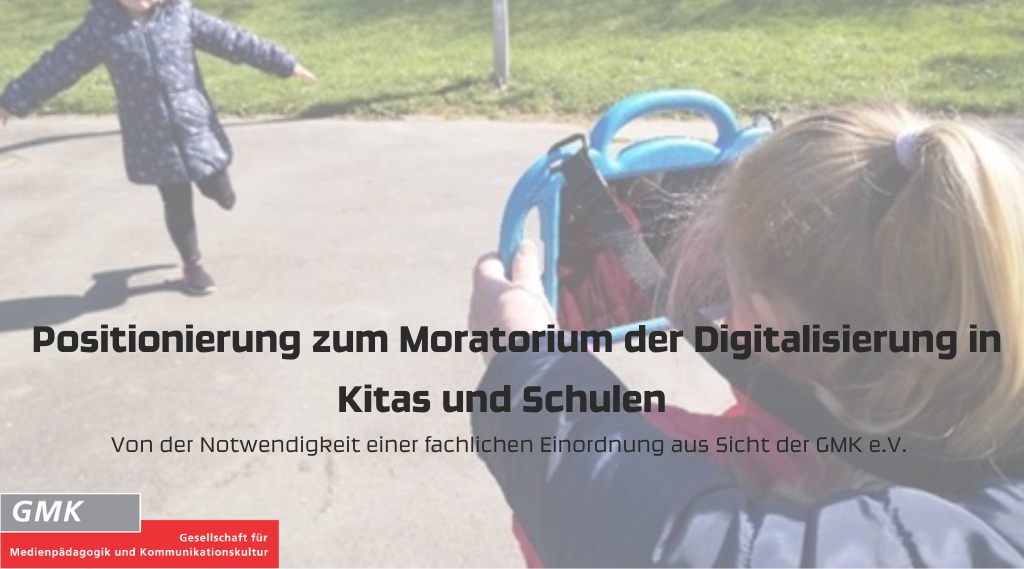 Kleines Mädchen fotografiert anderes kleines Mädchen mit Tablet; Text: Positionierung zum Moratorium der Digitalisierung in Kitas und Schulen. Von der Notwendigkeit einer fachlichen Einordnung aus Sicht der GMK e.V.
