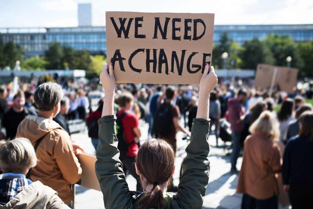 Eine Rückansicht von Menschen mit Plakaten und Plakaten zum globalen Streik für den Klimawandel.