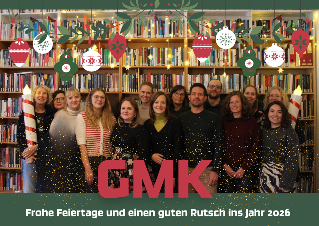 Alle GMK-Mitarbeiter*innen vor einer Bücherwand
