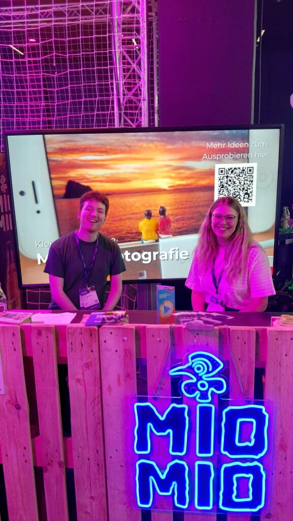 Madleine Salmen und Patrick Schwagmeier vom GMK-M-Team sitzen am Partnerstand
