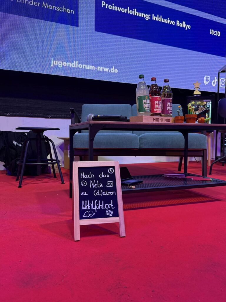 Schild auf der Bühne mit der Aufschrift „Mach das Netz zu deinem Wohlfühlort“