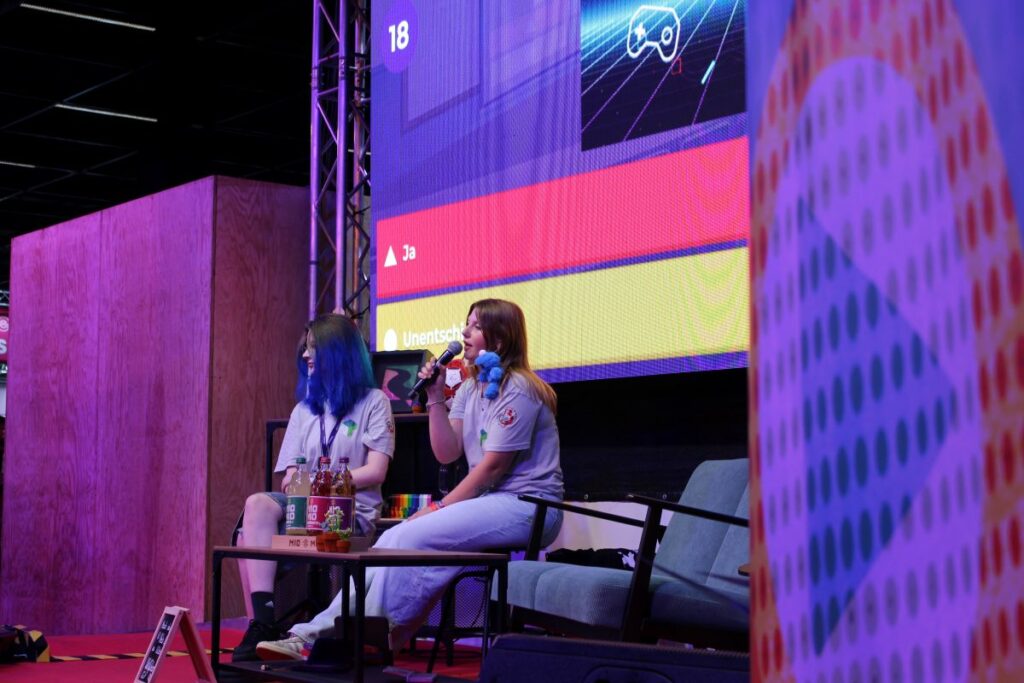 Zwei Personen sitzen auf der Bühne und sprechen über Sexismus in Games